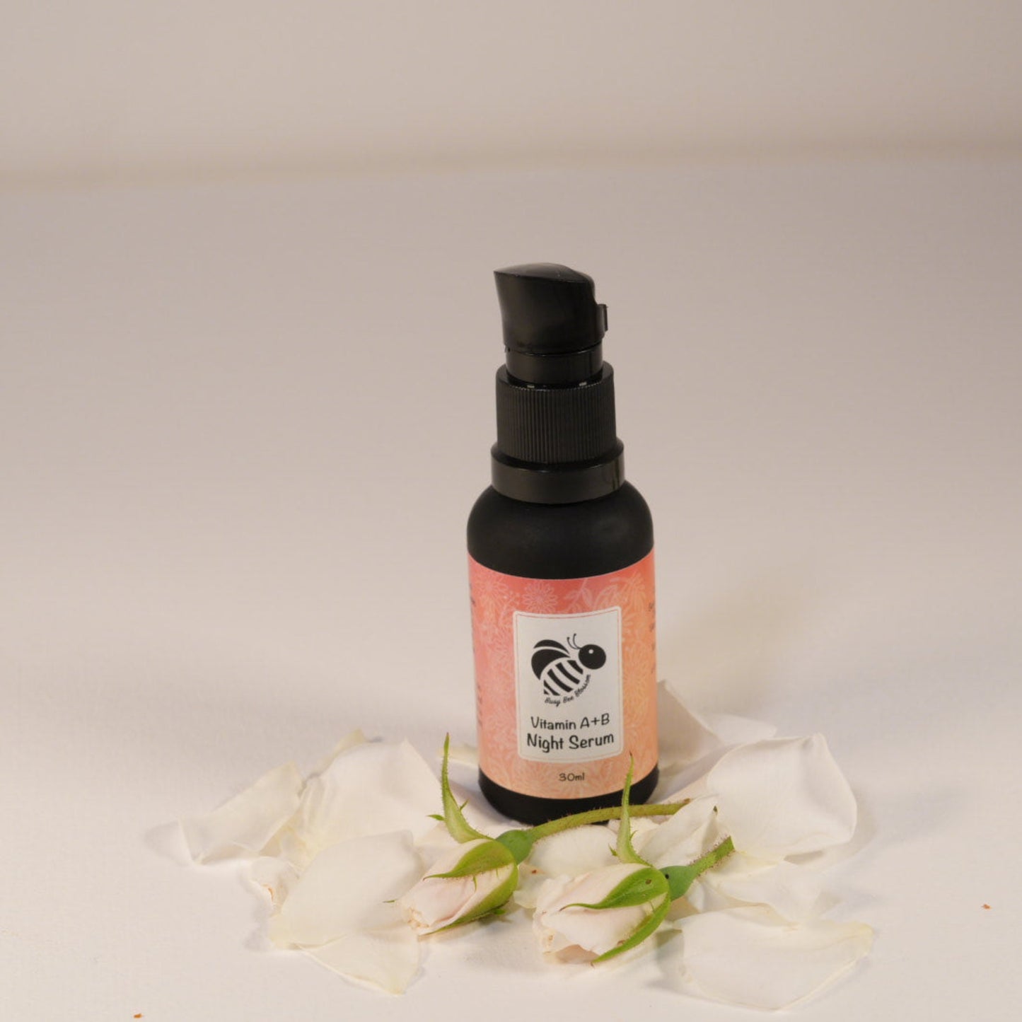 Vitamin A + B Night Serum in a black matt glass bottle with roses