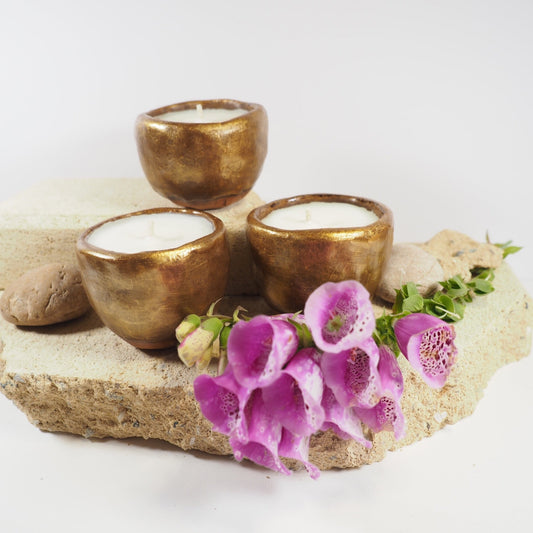 Bisque fired ceramic candle pots in gold glaze filled with coconut and soy wax
