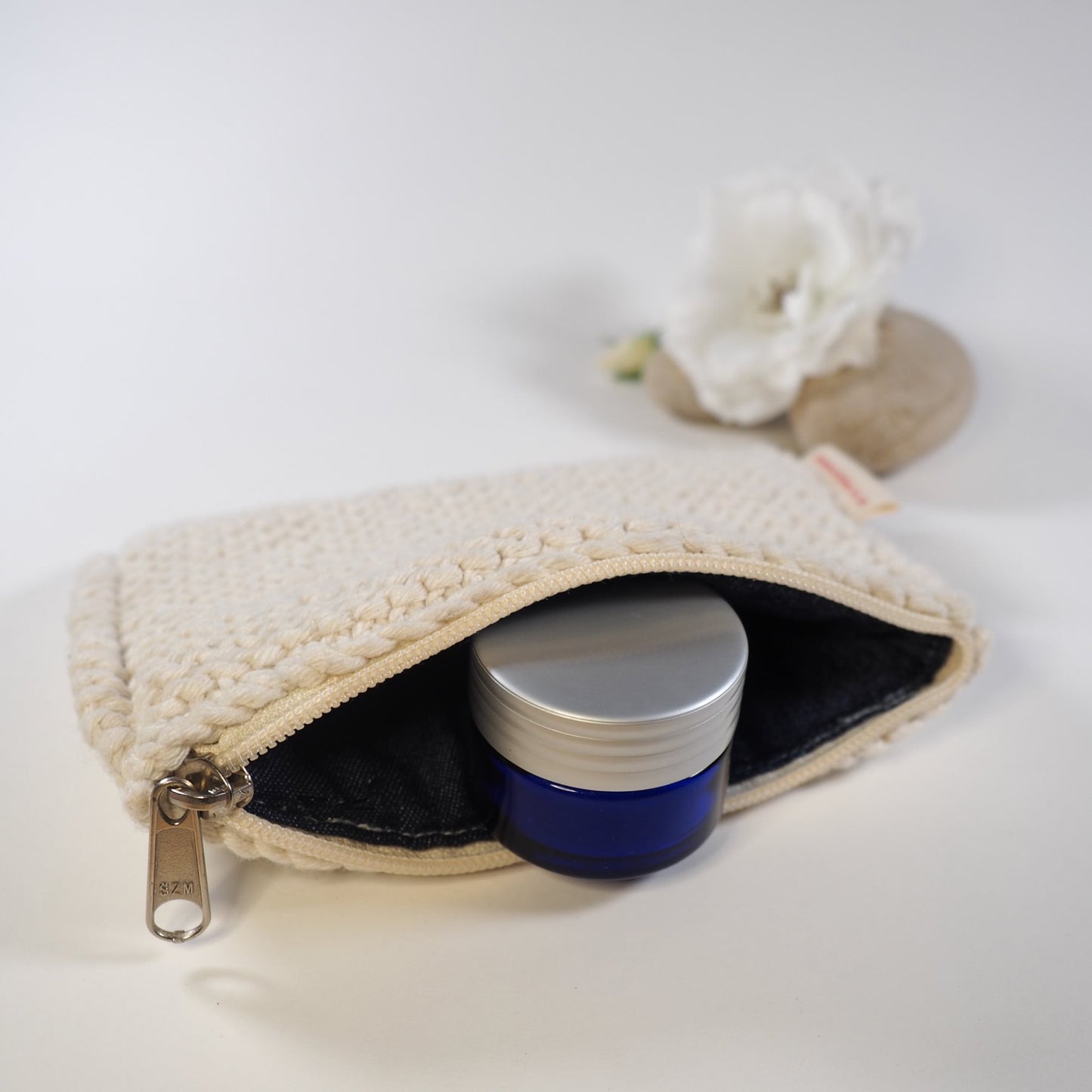 Cotton lip balm bag opened showing cotton lining and lip balm inside.
