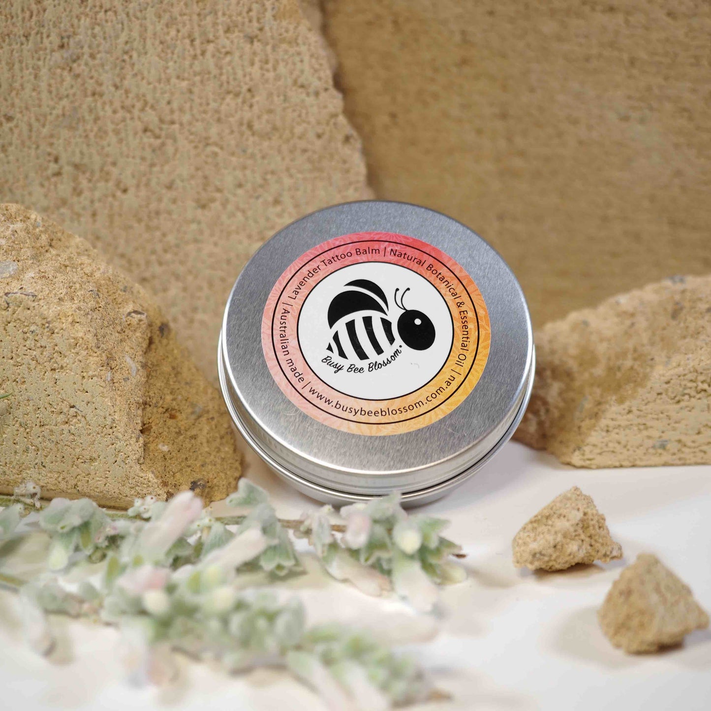 Organic Lavender Tattoo Balm with stone background and flowers