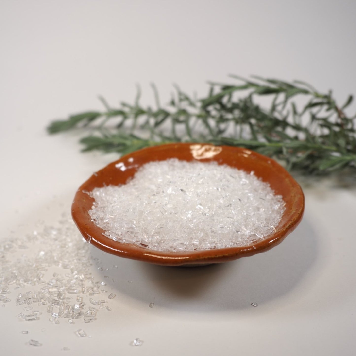 Close up of Sweet Orange Blossom Bath Salt in ceramic dish with flower