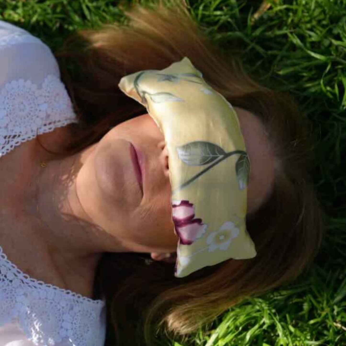 Louise with floral chrysanthemum silk eye pillow draped over eyes