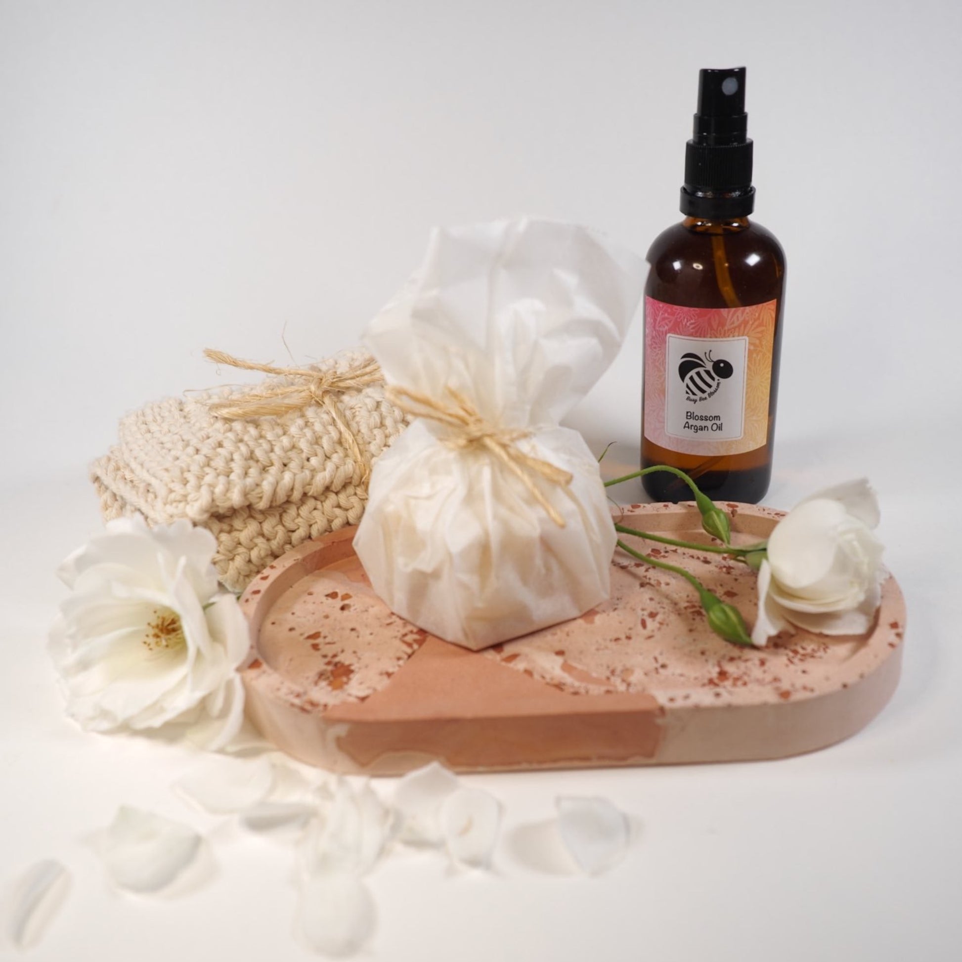 Blossom Pure Moroccan Argan Oil with oval cement dish, face cloth, cleansing bar soap and roses.