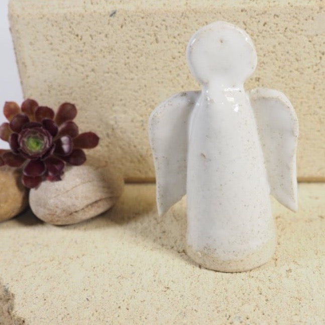 Ceramic angel candle snuffer in whit speckle glaze.