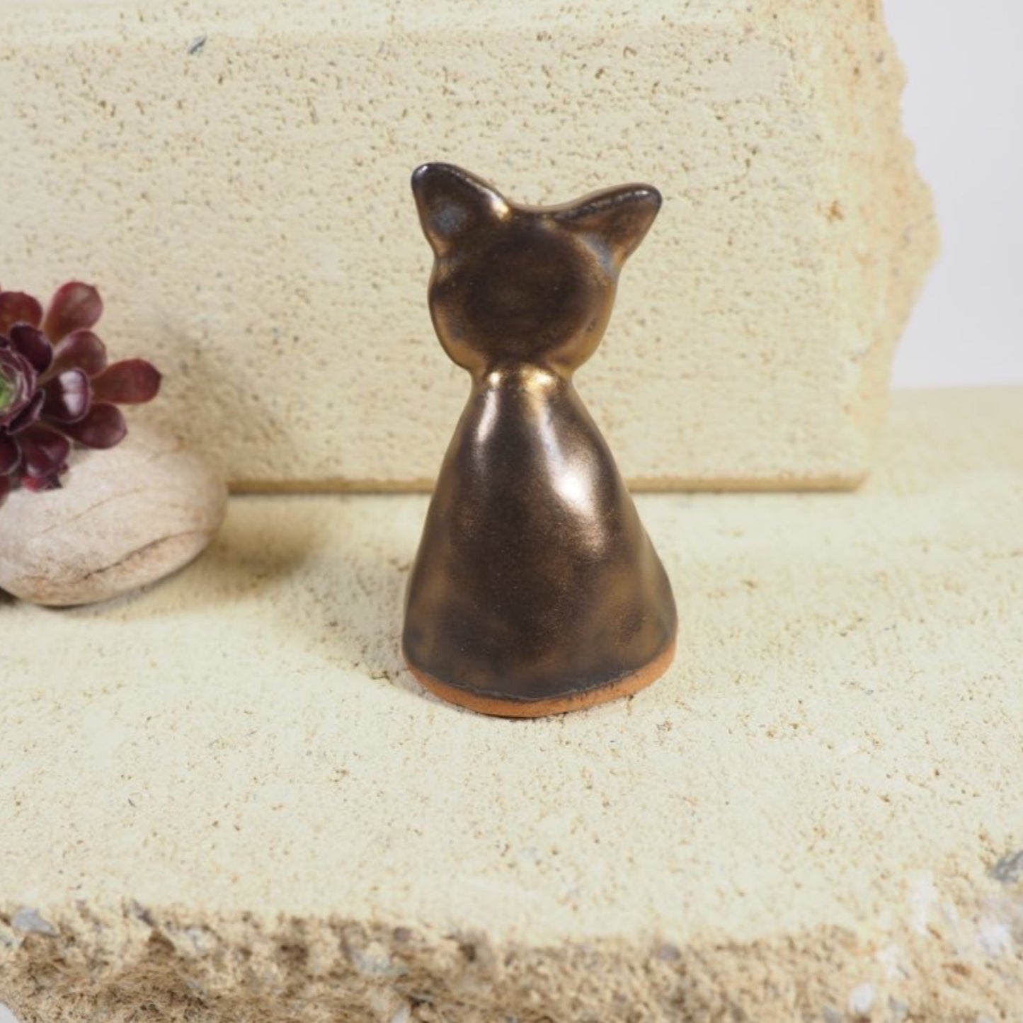 Ceramic candle snuffer in cat shape with gold glaze.