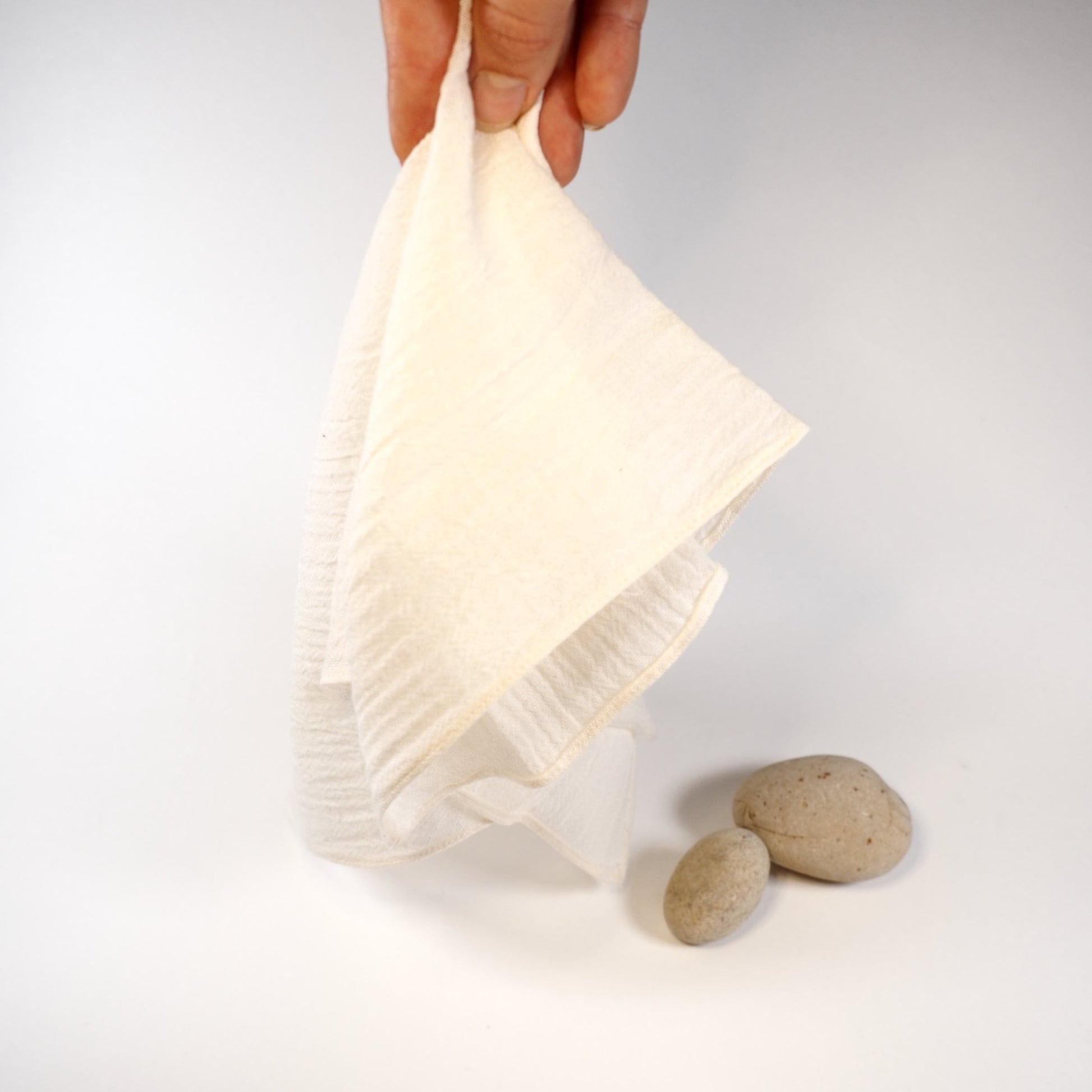 Hands holding a soft, organic cotton muslin facecloth for everyday gentle cleansing, 