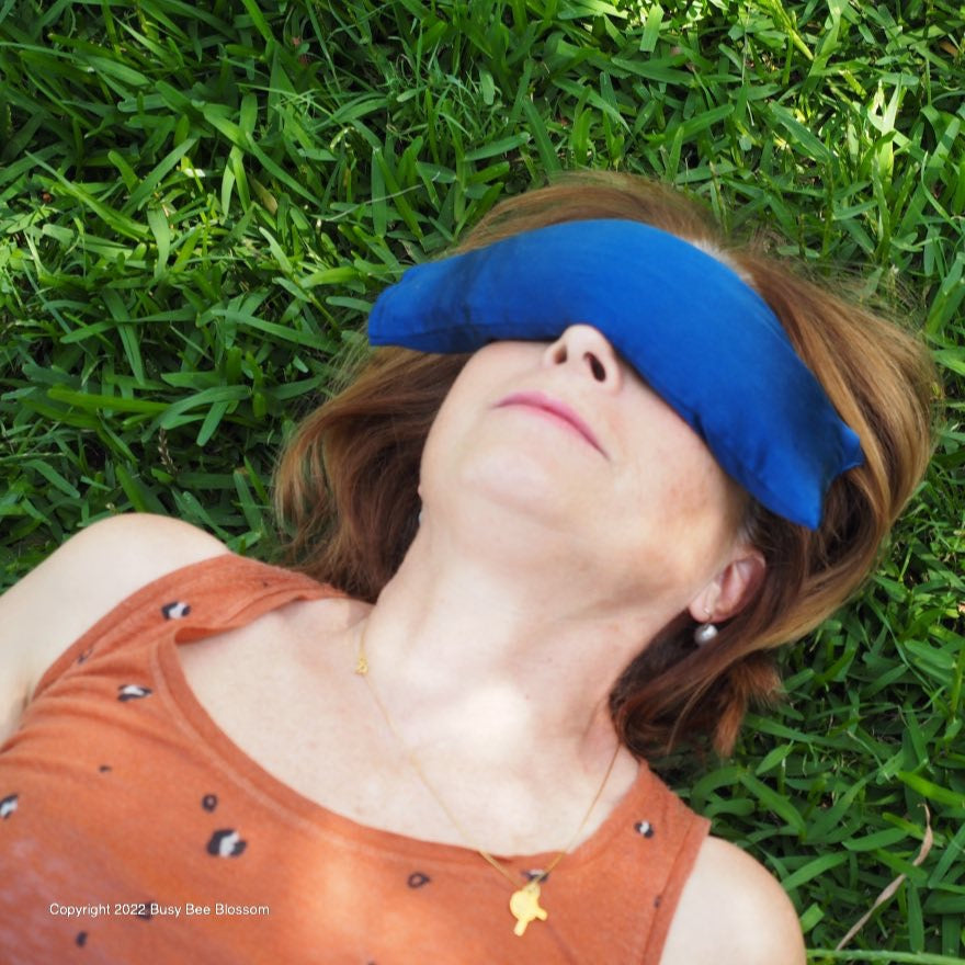 Louise relaxing in the grass with a blue silk lavender eye pillow