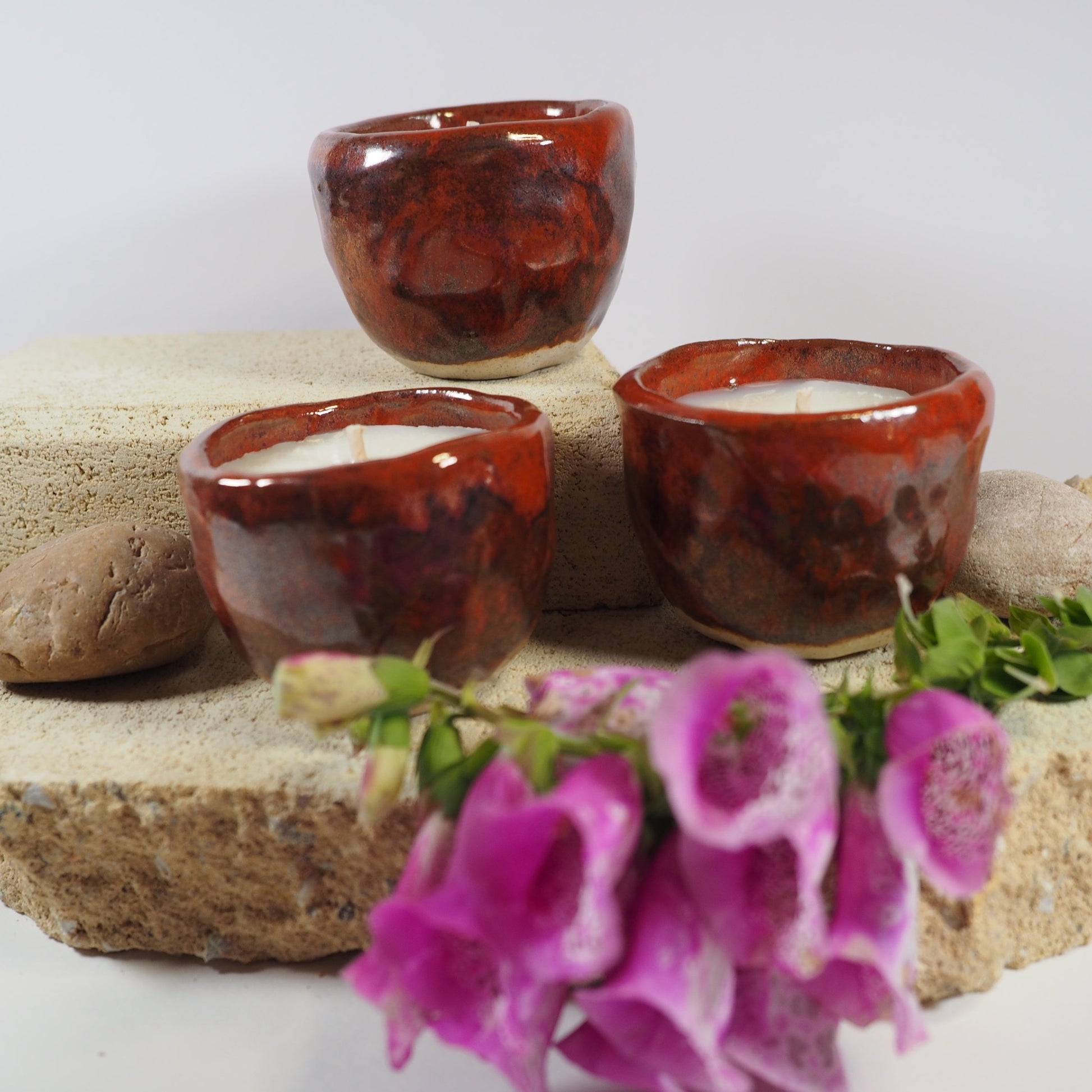 Ceramic bisque fired candle pots in tomato red glaze filled with coconut and soy wax